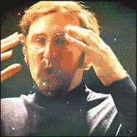 A man miming his mind being blown, his head dissolving into a starfield.