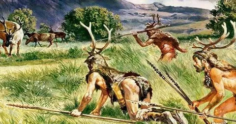 A painting of hunter-gatherers stalking deer across open grassland.